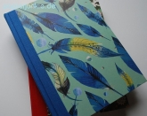 Geschenkpapier Federn, blau/gelb auf Grn